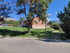View of home's exterior featuring a mountain view, a lawn, and brick siding