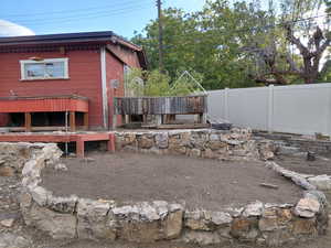 View of workshop behind the garage with a fenced backyard and garden planters