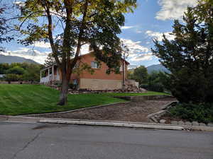 View of property exterior with a mountain view and a yard, RV or Trailer parking