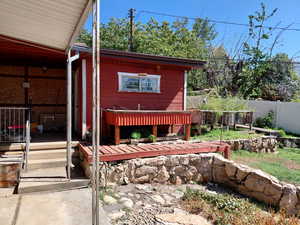 View of backyard with a wooden deck and grow boxes