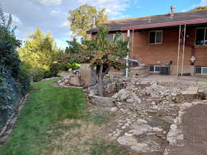 View of side of property with roof with shingles and a patio