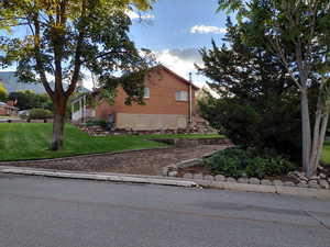 View of side of property with a yard and brick siding, RV or Trailer Parking