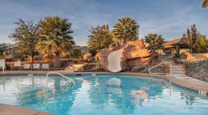 Community pool featuring a water slide and a patio area