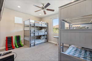 Carpeted bedroom featuring ceiling fan and recessed lighting