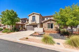 Mediterranean / spanish home with concrete driveway, stucco siding, a garage, stone siding, and a tiled roof