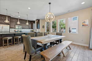 Dining room with wood tiled floors, recessed lighting, plenty of natural light, and a chandelier