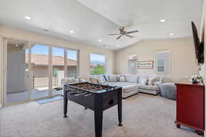 Rec room with plenty of natural light, light colored carpet, lofted ceiling, recessed lighting, and a ceiling fan