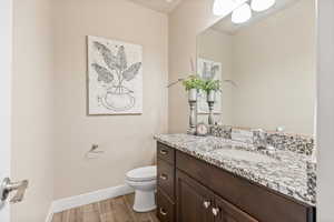 Half bathroom with wood finish floors and vanity