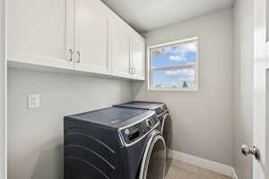Washroom featuring cabinet space and separate washer and dryer