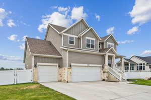 Craftsman-style house featuring a gate, board and batten siding, driveway, and covered porch