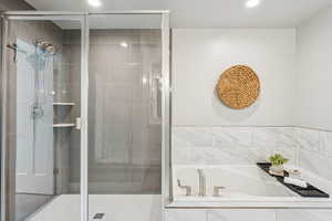 Full bath with a shower stall, a garden tub, and recessed lighting