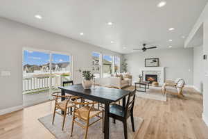 Dining space featuring recessed lighting, a fireplace, a ceiling fan, and light wood-type flooring