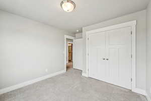 Unfurnished bedroom with carpet and a closet
