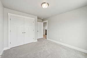 Unfurnished bedroom featuring carpet flooring and a closet