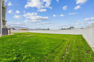Fenced backyard featuring a mountain view, stairway, and a patio area