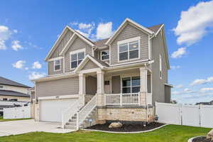 Craftsman inspired home with stone siding, a garage, covered porch, concrete driveway, and stairs