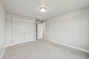 Unfurnished bedroom with carpet and a closet