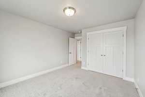 Unfurnished bedroom with carpet flooring and a closet