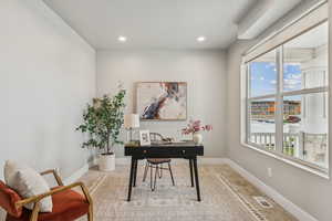Office space with light colored carpet and recessed lighting