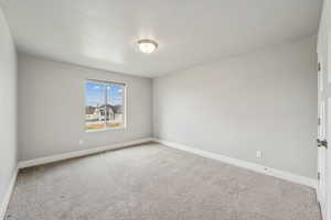 Empty room with carpet flooring and baseboards