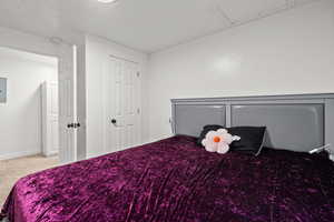 Carpeted bedroom featuring electric panel and baseboards
