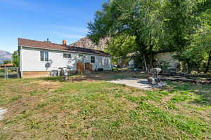 Rear view of house featuring a mountain view, a chimney, and a patio area