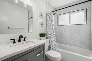 Bathroom featuring shower / bath combo with shower curtain and vanity
