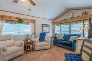 Living room featuring carpet, lofted ceiling, a ceiling fan, and ornamental molding