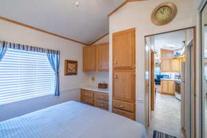 Bedroom with vaulted ceiling and crown molding