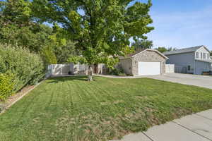 View of front of house with stone siding, concrete driveway, and an attached garage