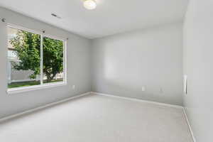 Carpeted spare room featuring baseboards
