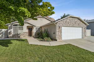 Ranch-style house with stone siding, stucco siding, driveway, and an attached garage