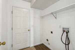Washroom with dark wood-style flooring, washer hookup, and hookup for an electric dryer