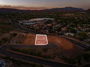 Aerial view of property and surrounding area featuring property boundaries highlighted and a mountain backdrop