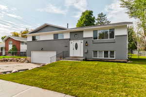 Bi-level home featuring brick siding, concrete driveway, and an attached garage