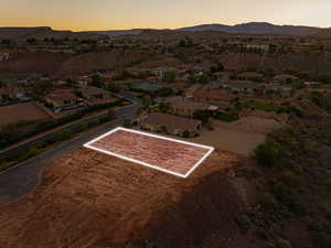 Aerial perspective of suburban area with property boundaries highlighted and a mountain backdrop