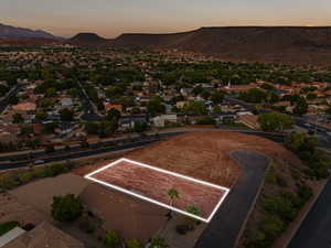 Aerial perspective of suburban area featuring property parcel outlined and a mountain backdrop