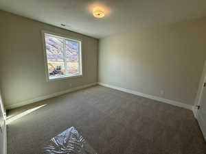 Bedroom with light colored carpet and a textured ceiling