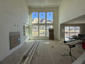 Living room featuring a towering ceiling, healthy amount of natural light, and a mountain view