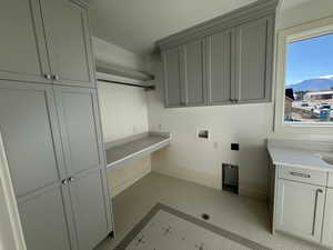 Laundry room with washer hookup, cabinet space, a mountain view, and a textured ceiling