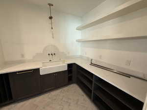 Panrty with open shelves, light stone counters, and pendant lighting