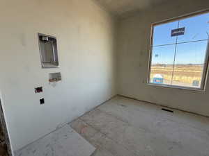 closet featuring hookup for a washing machine and a textured ceiling