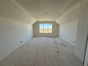 Additional living space featuring a textured ceiling and lofted ceiling