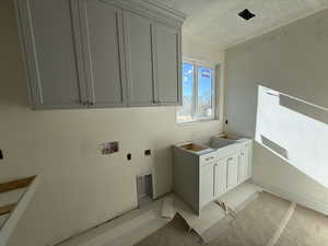 Laundry area featuring cabinet space, washer hookup, and a textured ceiling