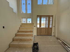 Entrance foyer featuring stairs and a high ceiling