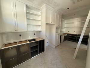 Pantry with white cabinetry, open shelves, and a textured ceiling