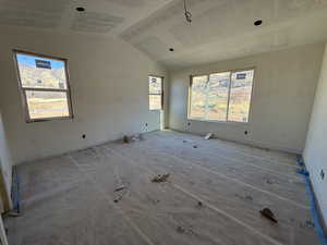 Spare room featuring healthy amount of natural light and vaulted ceiling