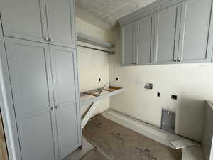 Laundry area featuring cabinet space, a textured ceiling, and washer hookup