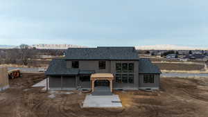 View of front of house featuring roof with shingles, a mountain view, a pergola, stucco siding, and a patio