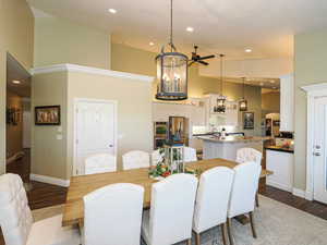 Dining space featuring recessed lighting, dark wood-type flooring, ceiling fan, a high ceiling, and a chandelier